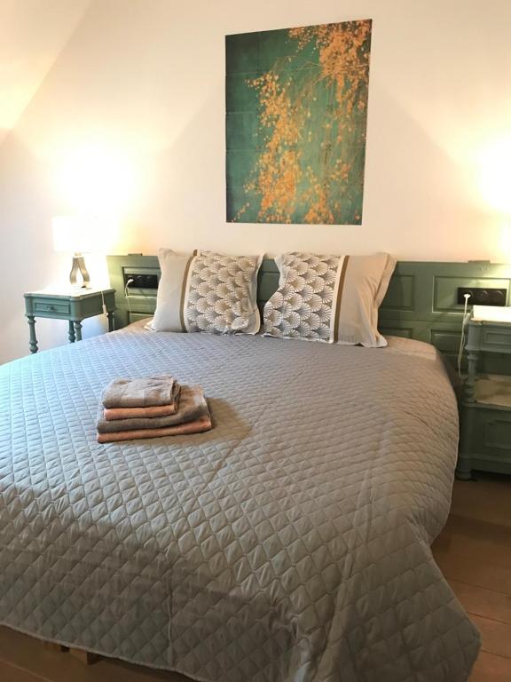 a bedroom with a bed with two towels on it at The Purple Courtyard in Beaune