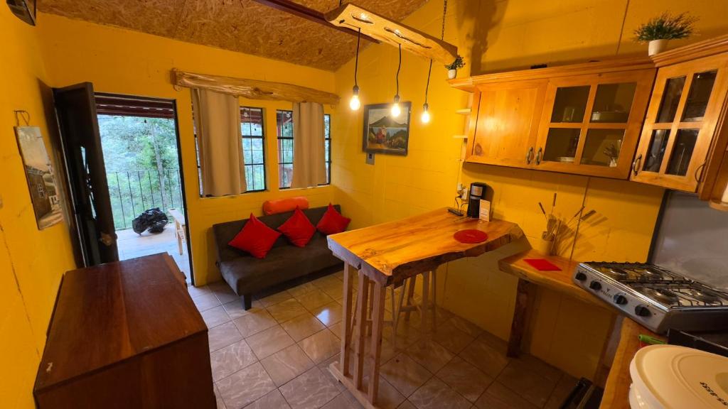 Una cocina con una mesa y un sofá en una habitación. en Villa Josefina, en Santiago Sacatepéquez