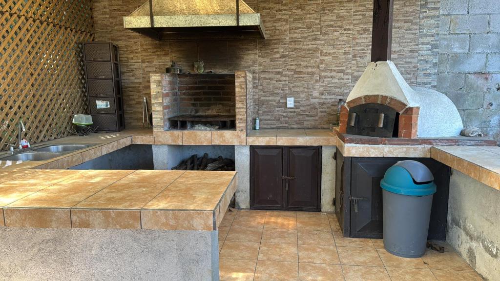 a large kitchen with a sink and a stove at Villa Josefina in Santiago Sacatepéquez