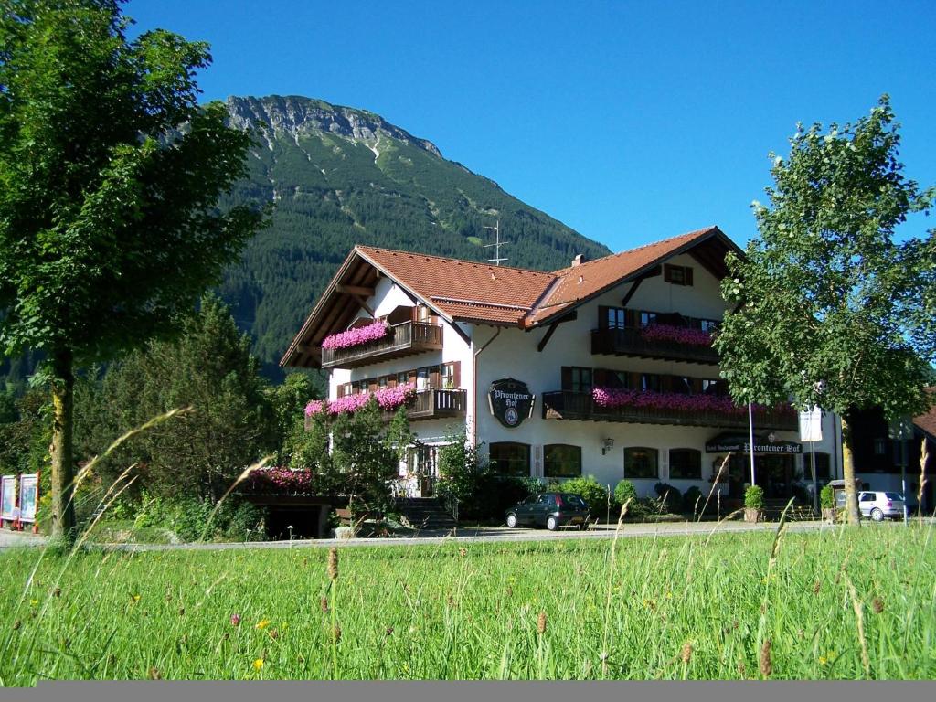 ein Haus mit einem Berg im Hintergrund in der Unterkunft Hotel Pfrontener Hof in Pfronten