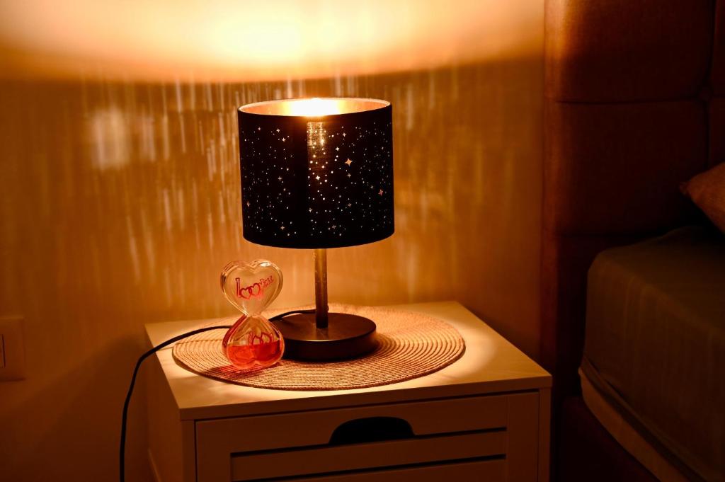 a lamp on a table with a vase on it at Hanan Apartmani in Novi Pazar