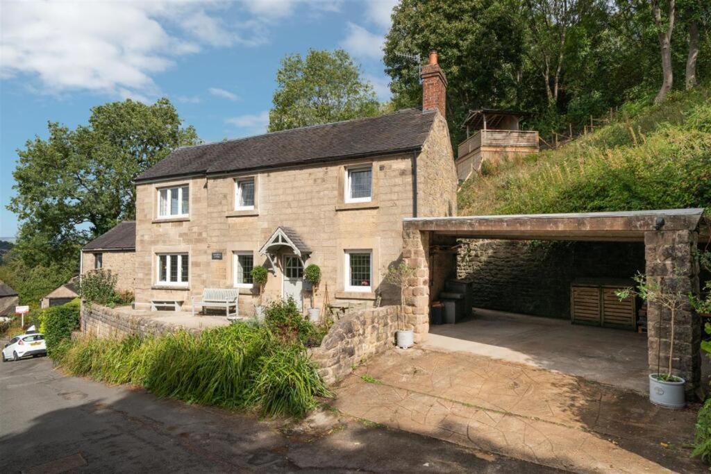 a large brick house with a garage in front of it at Cyclists Rest Matlock in Matlock