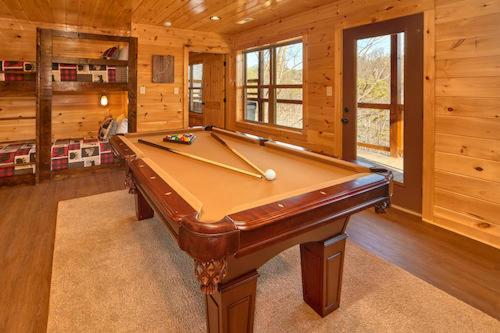 una mesa de billar en una habitación con paredes de madera en Majestic View, en Williamsburg
