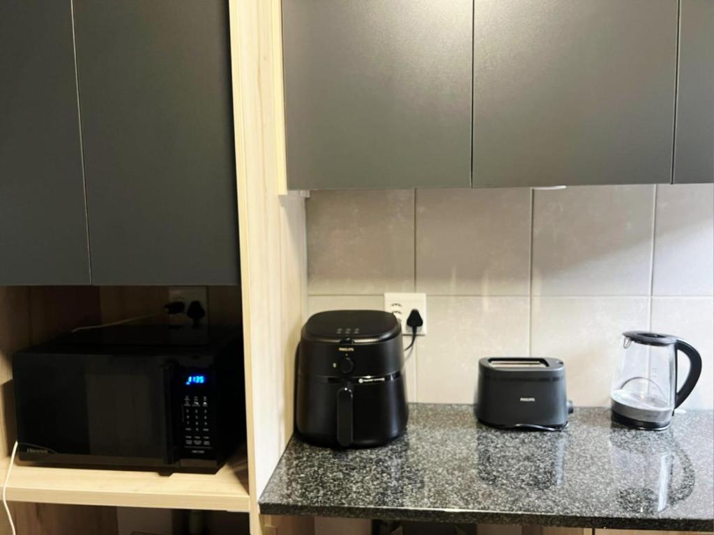 a kitchen counter with a coffee maker and a microwave at Felinga Guest House in Centurion
