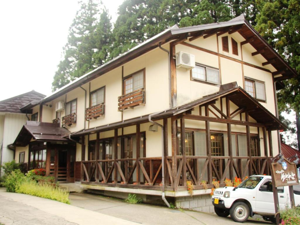 a white truck parked in front of a building at Lodge Yukiyama in Nozawa Onsen