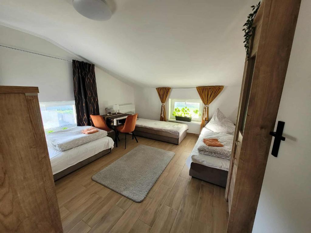 een woonkamer met 2 bedden en een bureau bij Agroturystyka Błądkowo 20A, Dom 11 miejsc in Błądkowo