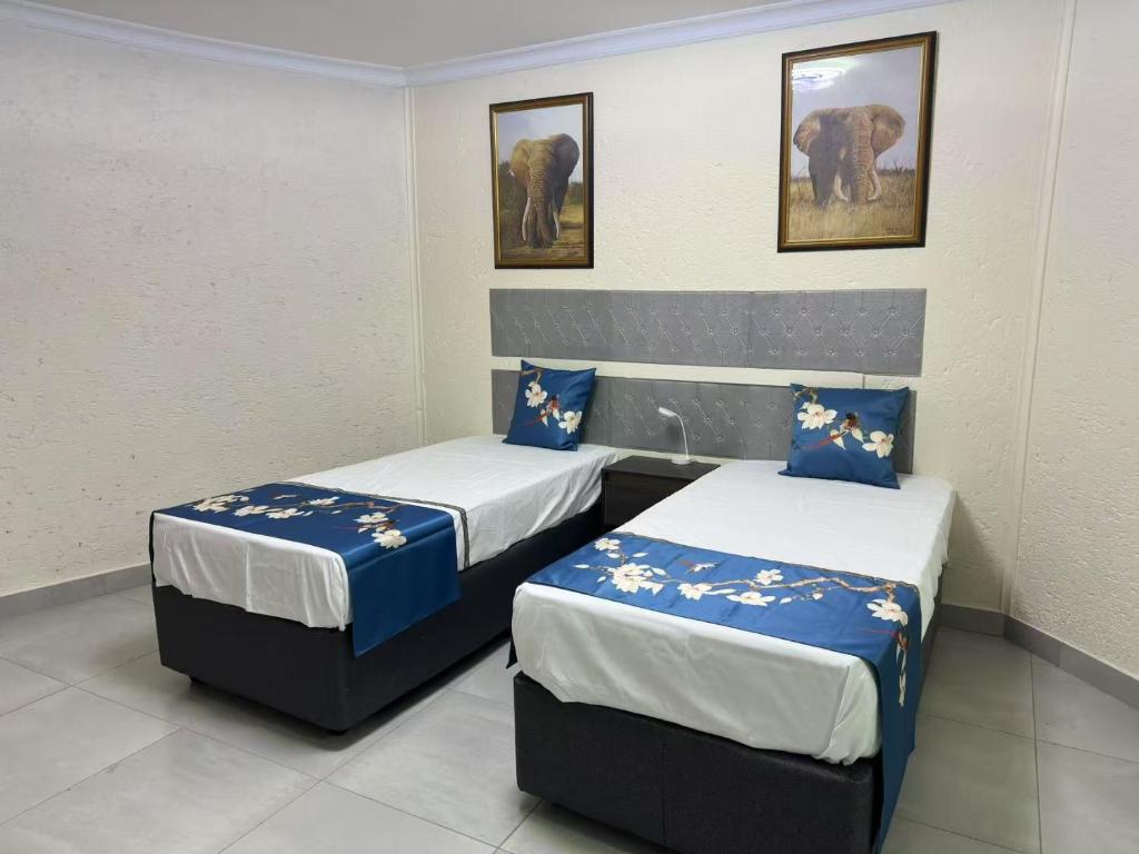a room with two beds and an elephant in it at Trinity S t a y in Benoni