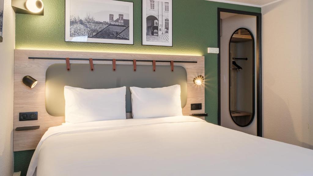 Ένα ή περισσότερα κρεβάτια σε δωμάτιο στο Campanile NATURE - Besançon Ouest Chateaufarine