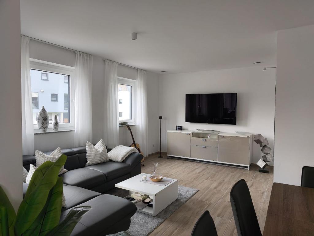 a living room with a couch and a tv at Annas Ferienwohnung in Wallerfangen