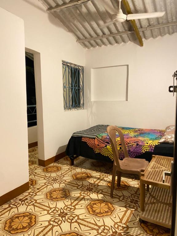 a bedroom with a bed and a chair and a table at Messianic guest house in Arambol
