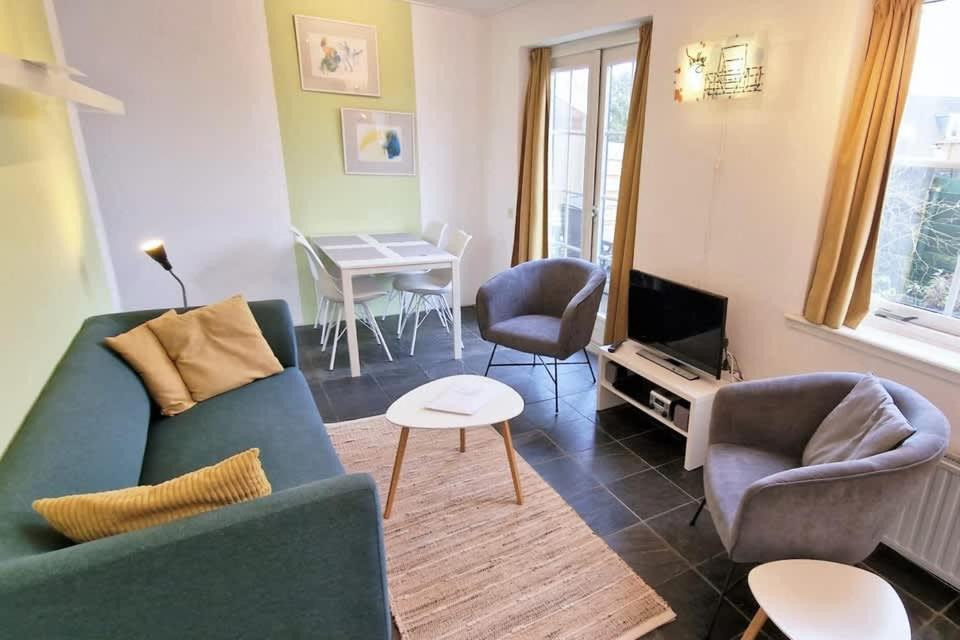 ドンブルグにあるHello Zeeland - Westweg 9Bのソファと椅子とテーブルのあるリビングルーム