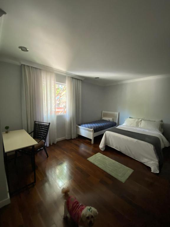 a bedroom with a bed and a dog on the floor at Quarto amplo e confortável in Sao Paulo
