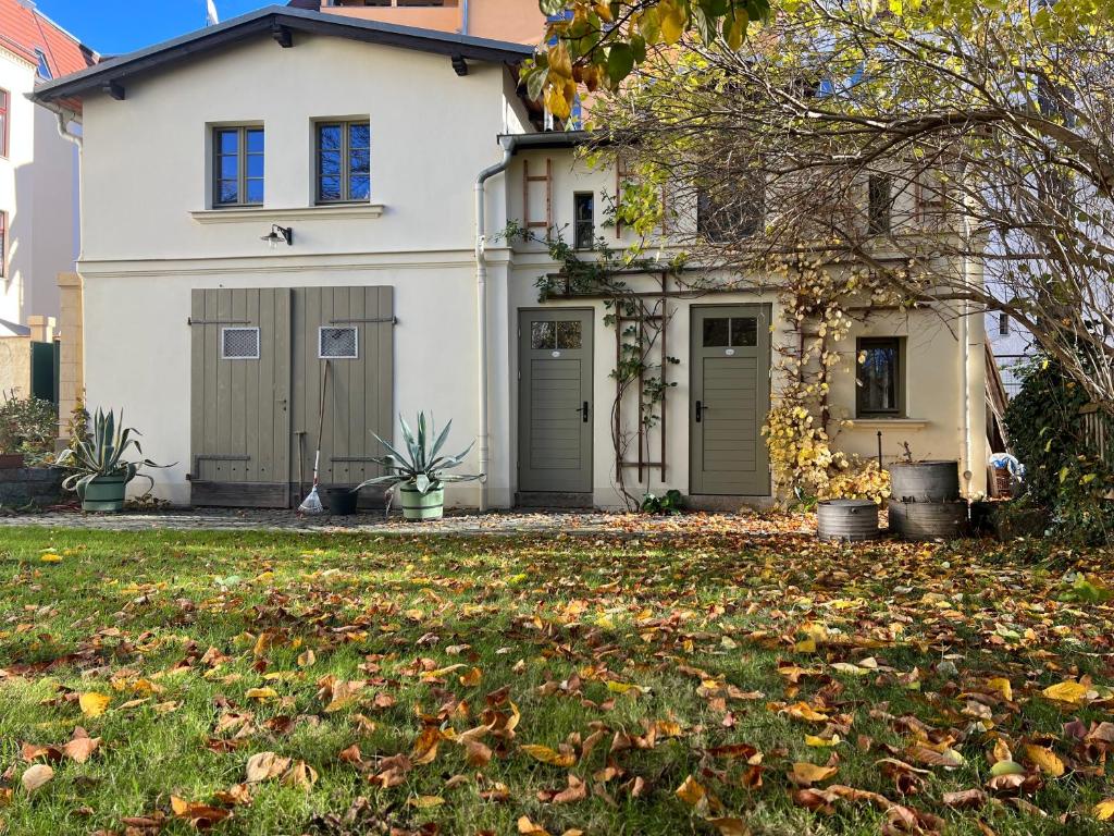 een wit huis met een tuin met bladeren op het gras bij Villa Adams in Görlitz
