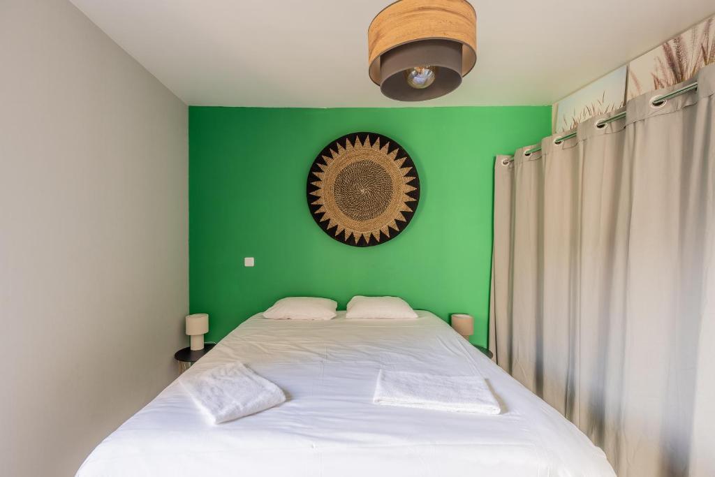 a bedroom with a green wall and a bed at Le petit Taison - Metz Hyper center in Metz