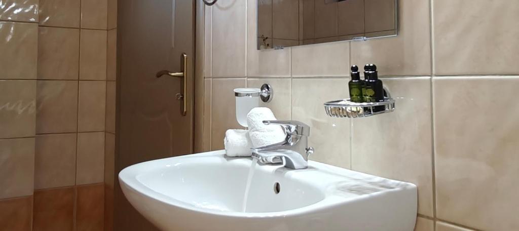 a white sink in a bathroom with a mirror at Mountain View Apartments in Kalavrita