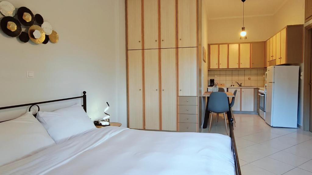 ein Schlafzimmer mit einem weißen Bett und einer Küche in der Unterkunft Mountain View Apartments in Kalavryta