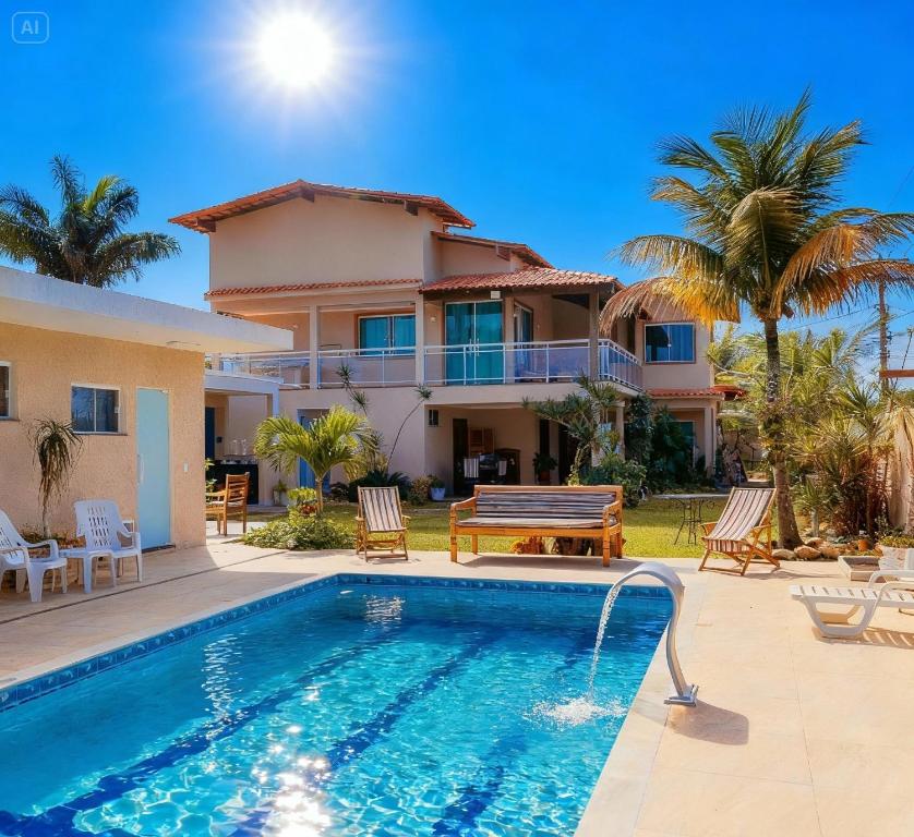 a villa with a swimming pool and a house at Pousada Recanto do Chef in Búzios