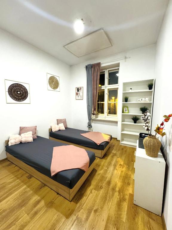 een slaapkamer met twee bedden en een raam bij Pokoje przy Rynku IV in Katowice
