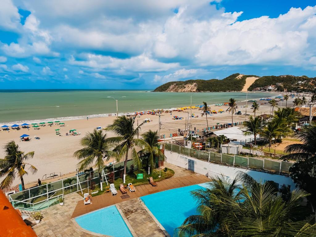 an aerial view of a beach with a swimming pool at Ponta Negra Beach Praiano Flat in Natal
