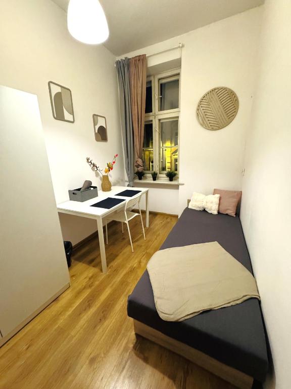 a bedroom with a bed and a desk in it at Pokoje przy Rynku III in Katowice