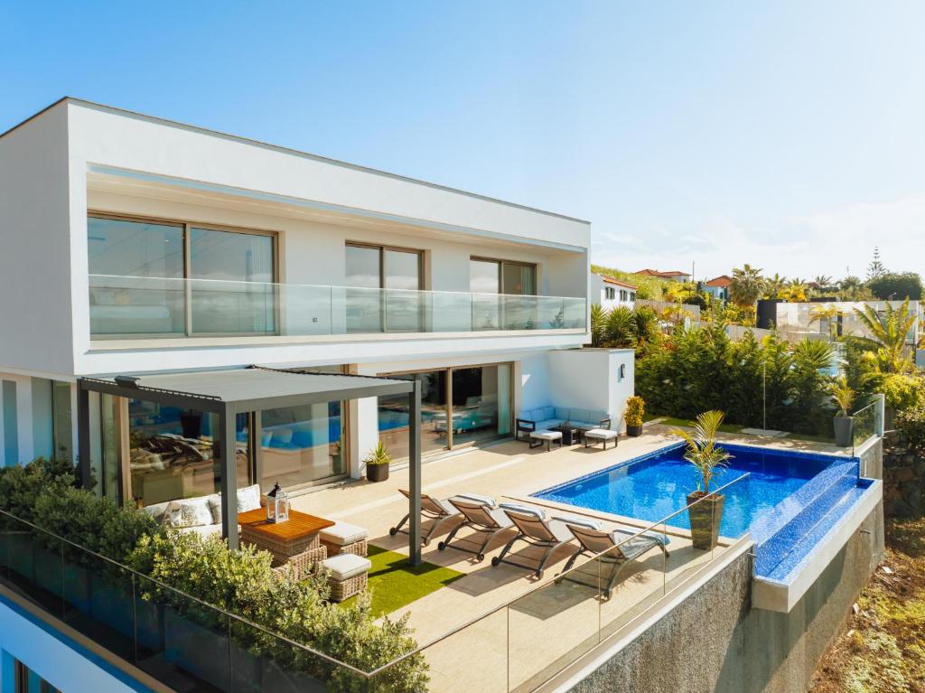 ein Bild von einem Haus mit einem Swimmingpool in der Unterkunft Lê Maison Deluxe Madeira - Where Peace is breathed and Luxury is felt! in Ponta do Sol