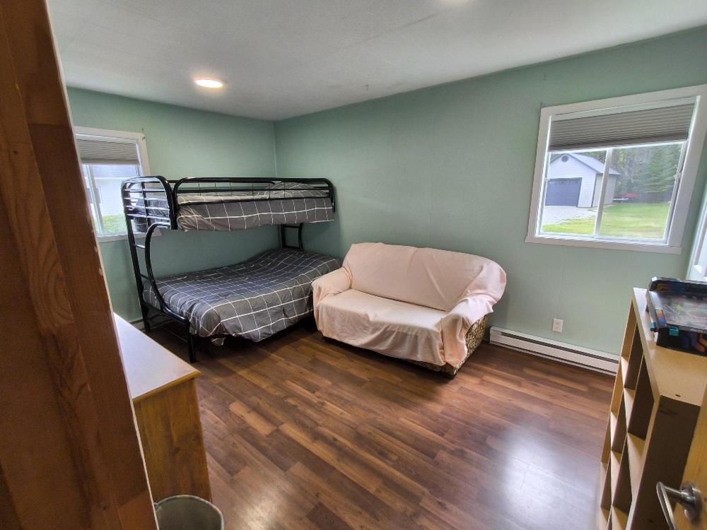 a room with two bunk beds and a chair at L'toile Filante in Saint Zenon