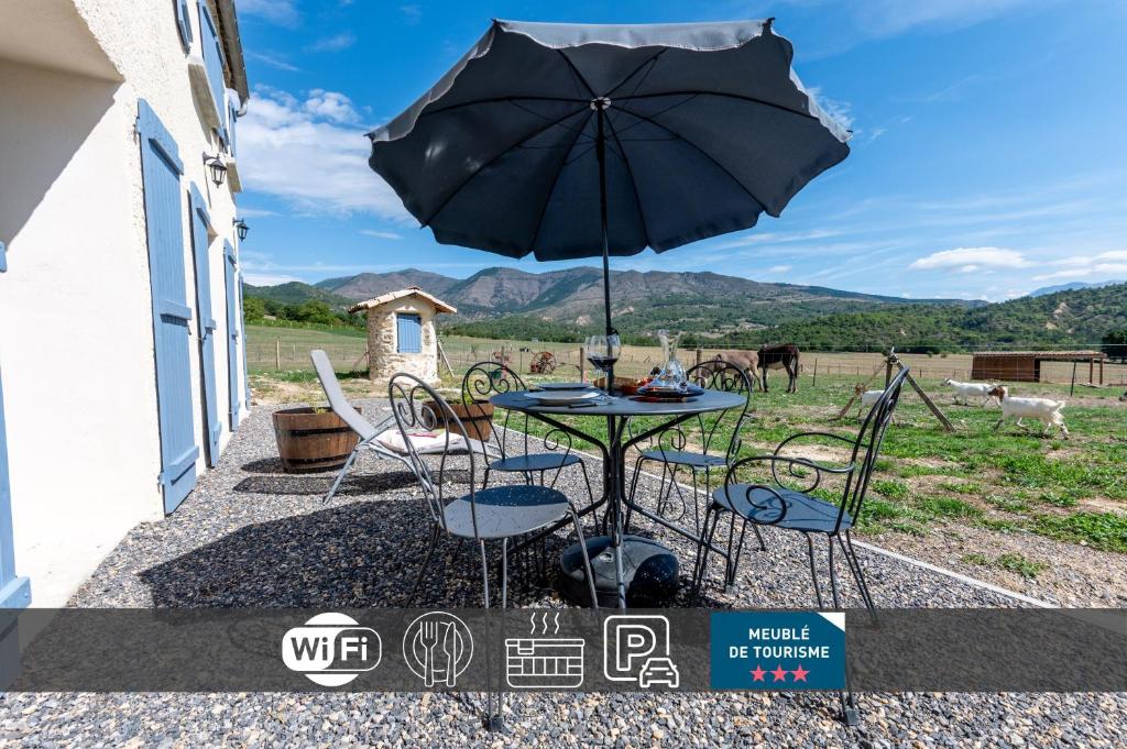 迪涅莱班Plaines-Provence Spa&Sauna的庭院内桌椅和遮阳伞