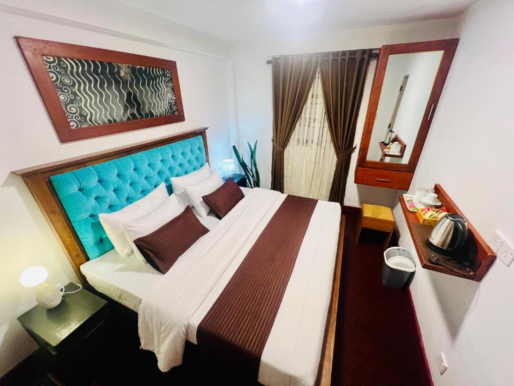 a bedroom with a large bed with a blue headboard at Ck homestay in Nuwara Eliya