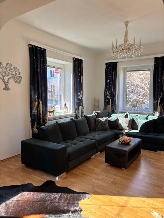 a living room with a black couch and a table at Ferienwohnung Hakuna Matata in Bad Aussee
