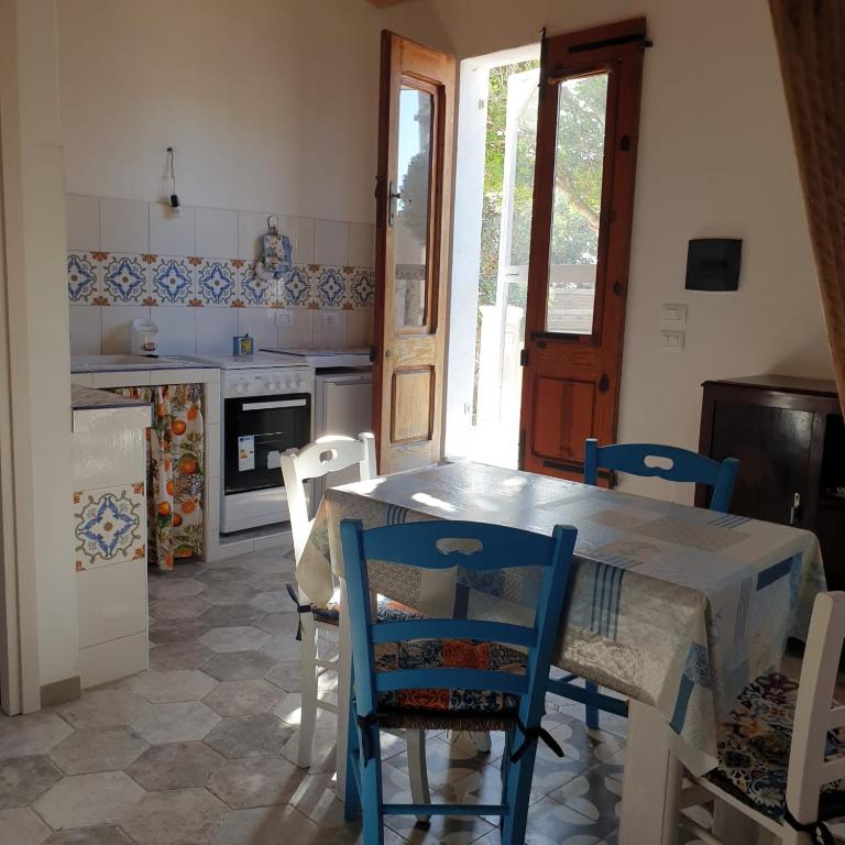 a kitchen with a table and chairs in a room at A Bugatta in Ìsola di San Pietro
