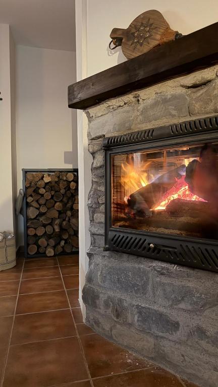 a living room with a stone fireplace with a fire at Mirador de Punta Corona in Borrastre