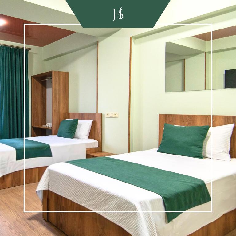 a hotel room with two beds and a mirror at Hotel Serenity in Tbilisi City