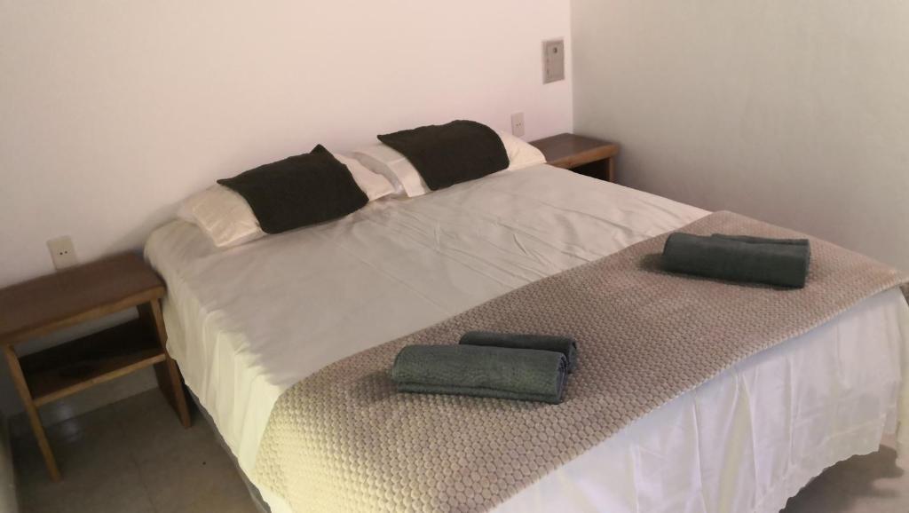 a bedroom with a bed with two green towels on it at Casa Angela María in Caacupé