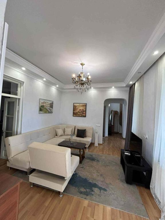 a living room with a white couch and a chandelier at Apartment 9 in Mtskheta