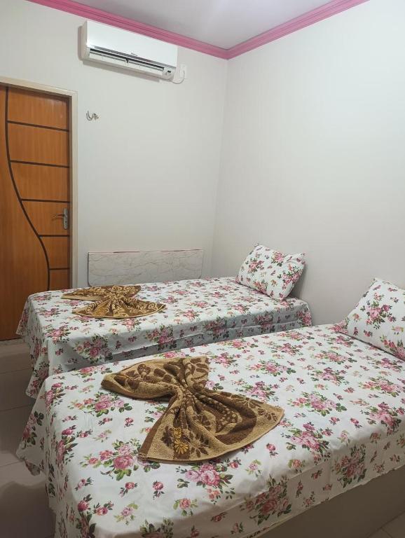 two beds sitting next to each other in a room at Eds pousada in Juazeiro do Norte