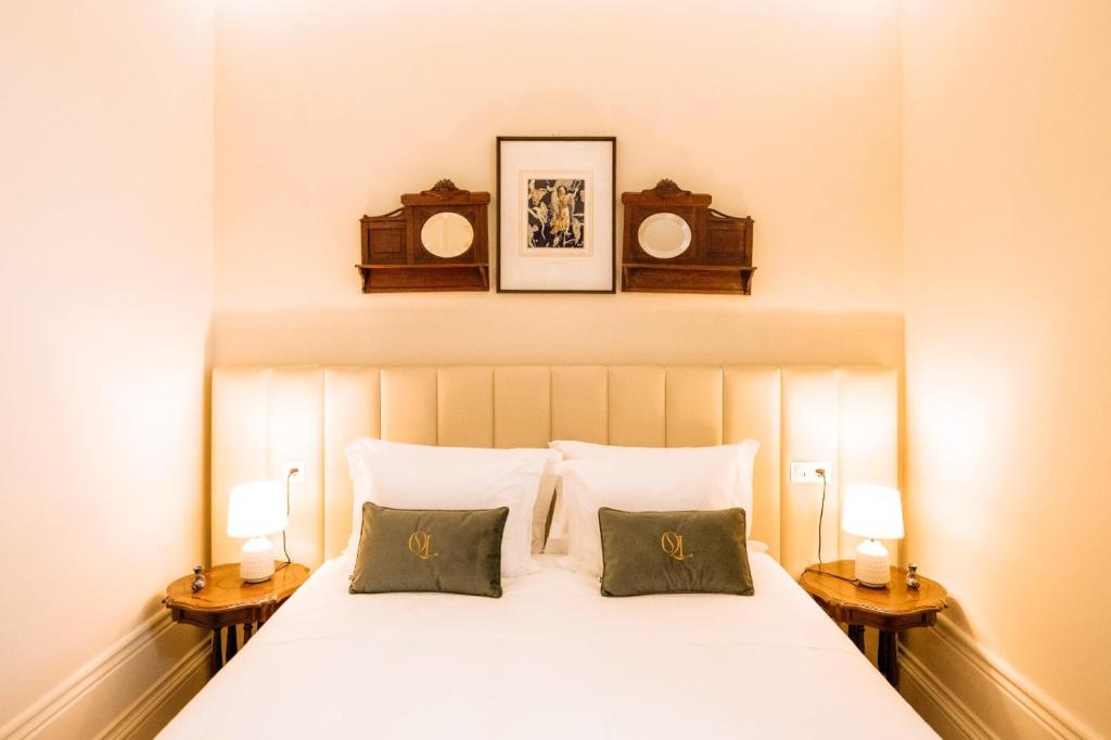 a bedroom with a white bed with two night stands at Quinta das Luzes by Casa dos Sequeiras in Vila Nova de Gaia