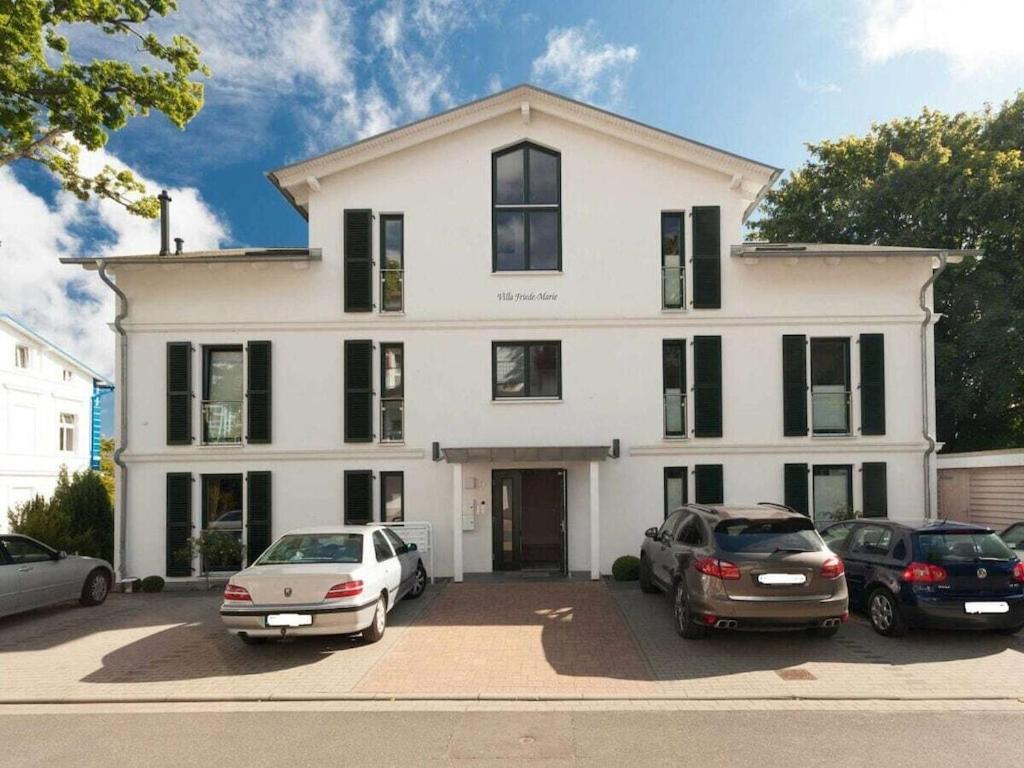 a white house with cars parked in front of it at One-bedroom apartment in Sassnitz
