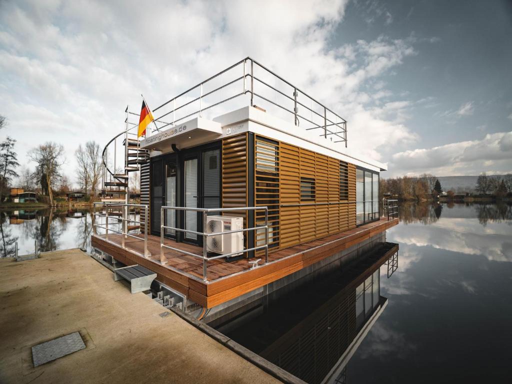 a house on a dock on a body of water at Schönes Hausboot in Höxter in Höxter