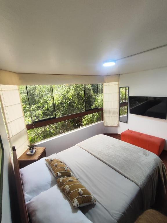 Un dormitorio con una cama y una ventana grande. en Céntrica habitación con vistas Larcomar, en Lima