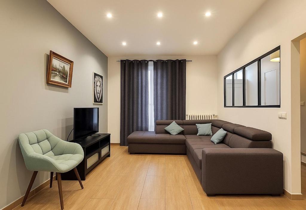 a living room with a couch and a television at Spacious house with garden, 15 minutes from Paris in Houilles