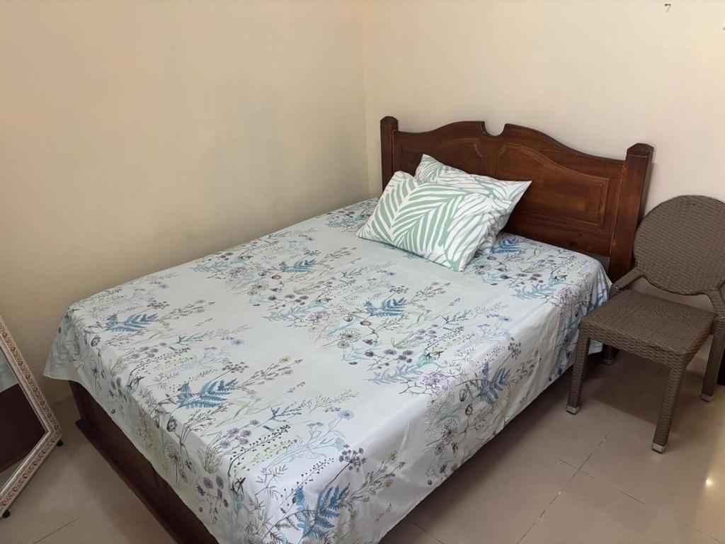 a bedroom with a bed with a pillow and a chair at Beachfront apartment-perfect sea escape! in Flic-en-Flac