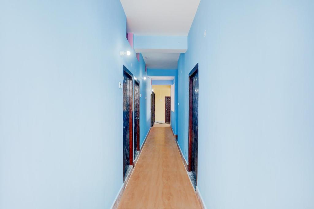 Un pasillo con paredes azules y suelos de madera. en SPOT ON Hotel Chandi, en Bihār Sharīf