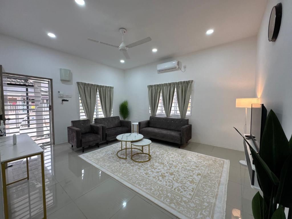 a living room with two couches and a table at Harees Homestay in Kuala Lipis