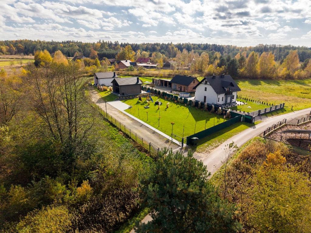 an aerial view of a farm with a house and a road at Biała chatka w Krzaczastym Zakątku 