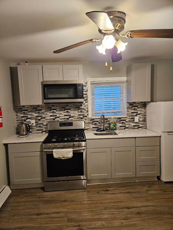 a kitchen with a stove and a ceiling fan at Entire Spacious House in New Jersey in East Orange