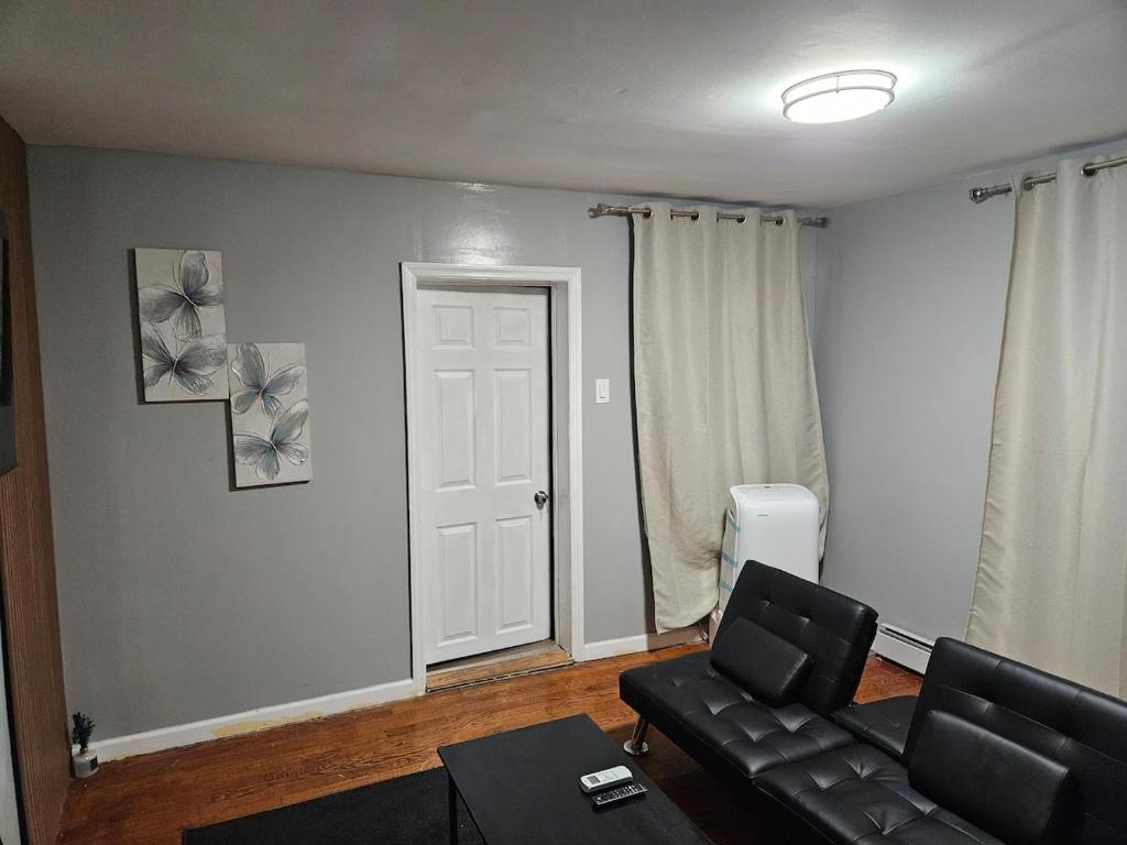 een woonkamer met een bank en een stoel bij Entire Spacious House in New Jersey in East Orange