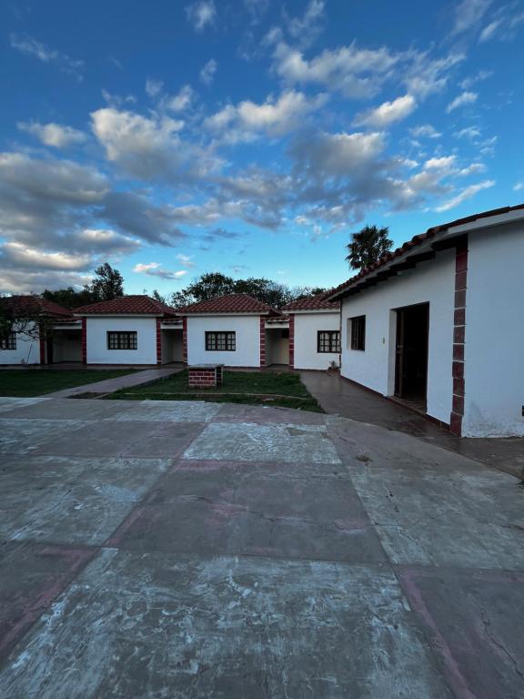 een rij witte gebouwen met een parkeerplaats bij Brisas del Cadillar in Tarija