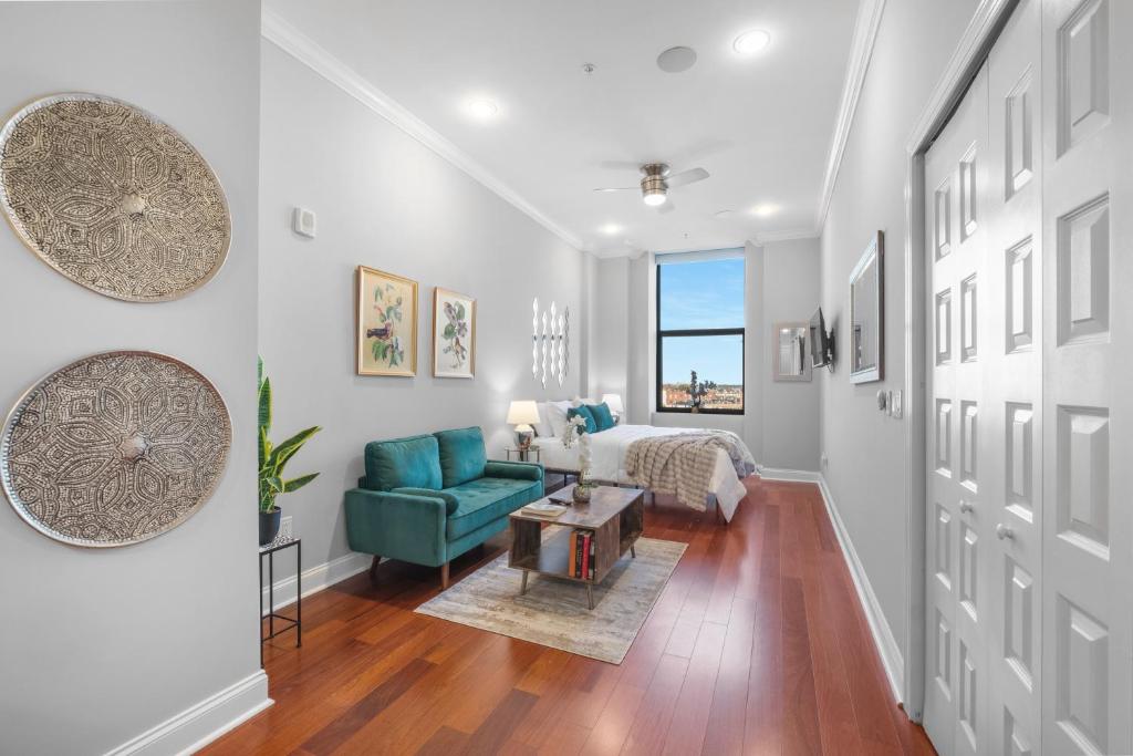 een woonkamer met een bed en een blauwe stoel bij Luxury Studio Loft Rooftop View & Pool in Philadelphia