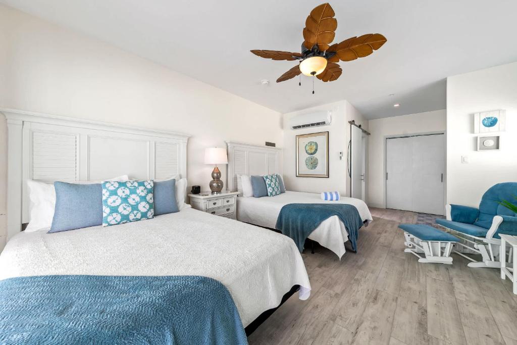 ein Schlafzimmer mit zwei Betten und einem Deckenventilator in der Unterkunft The Sand Dollar at Cottages in Sand Bluff