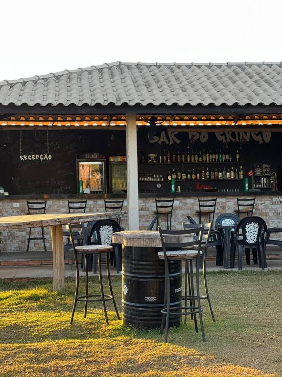 a table and chairs in front of a bar at Hotel Fazenda Vitoria in Pindorama
